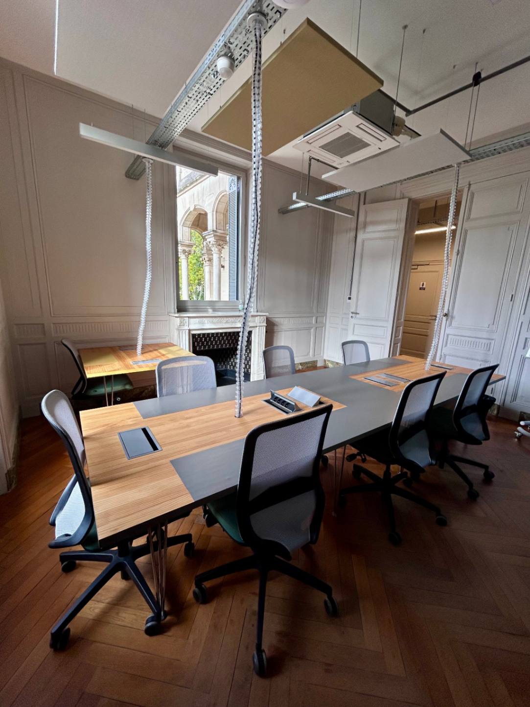 Bureau privatif Villa Maria — table de réunion avec parquet et boiseries